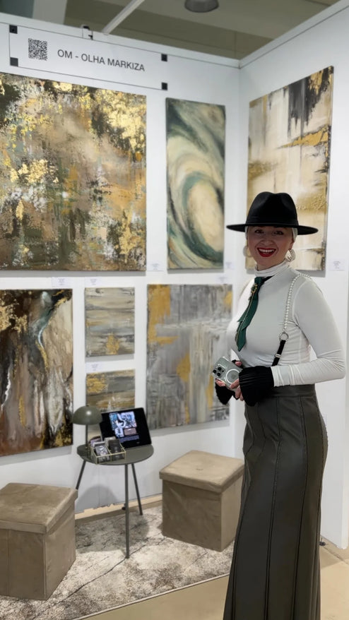 Woman in a stylish outfit standing in front of abstract art at an exhibition.